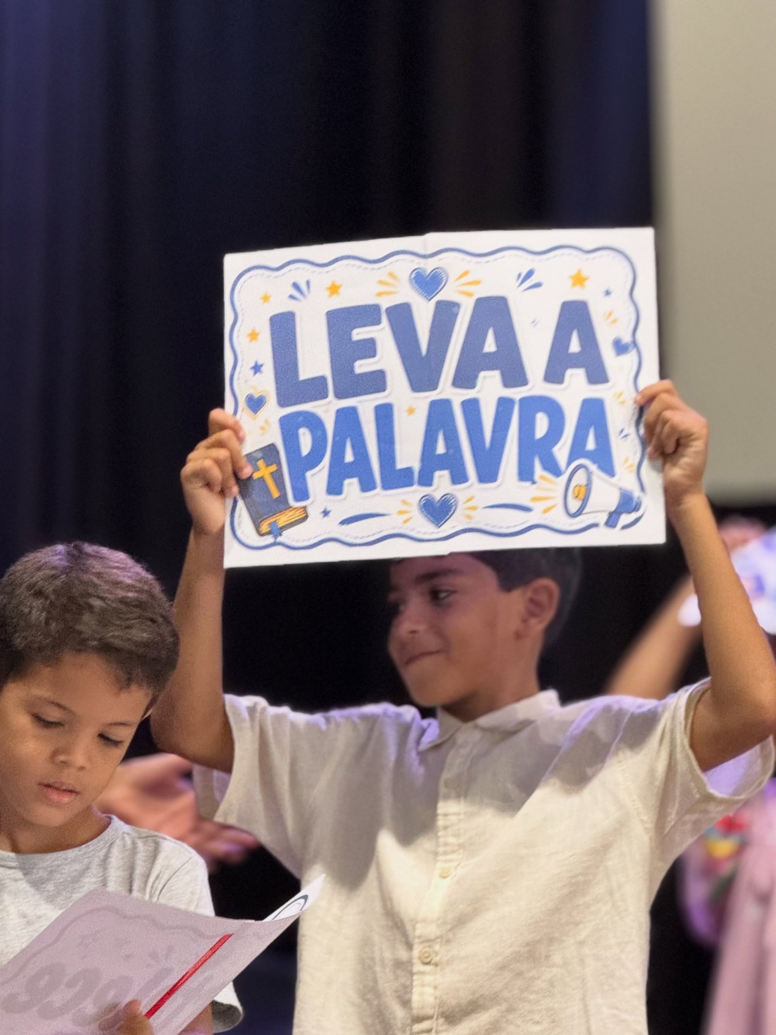 Criança segurando placa Leva a Palavra